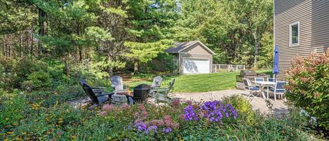 A backyard with a lawn, patio furniture, and a small shed.