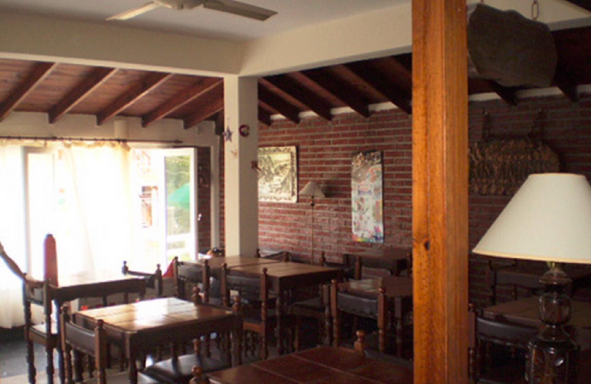A room with wooden furniture, a brick wall, and a ceiling fan.