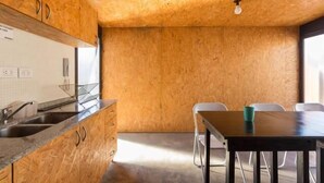 Une cuisine avec des meubles en bois, un évier et un coin repas comprenant une table et des chaises.