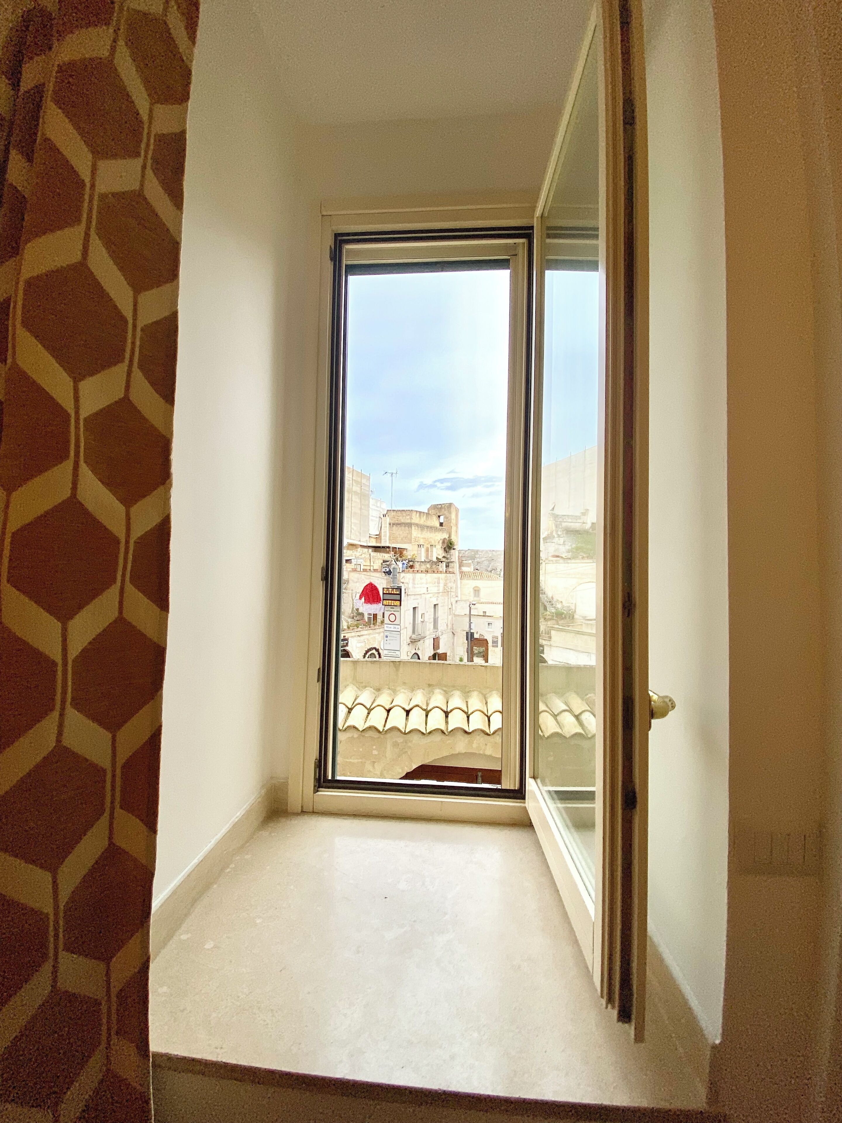 Une chambre d’angle avec une fenêtre donnant sur le paysage urbain.