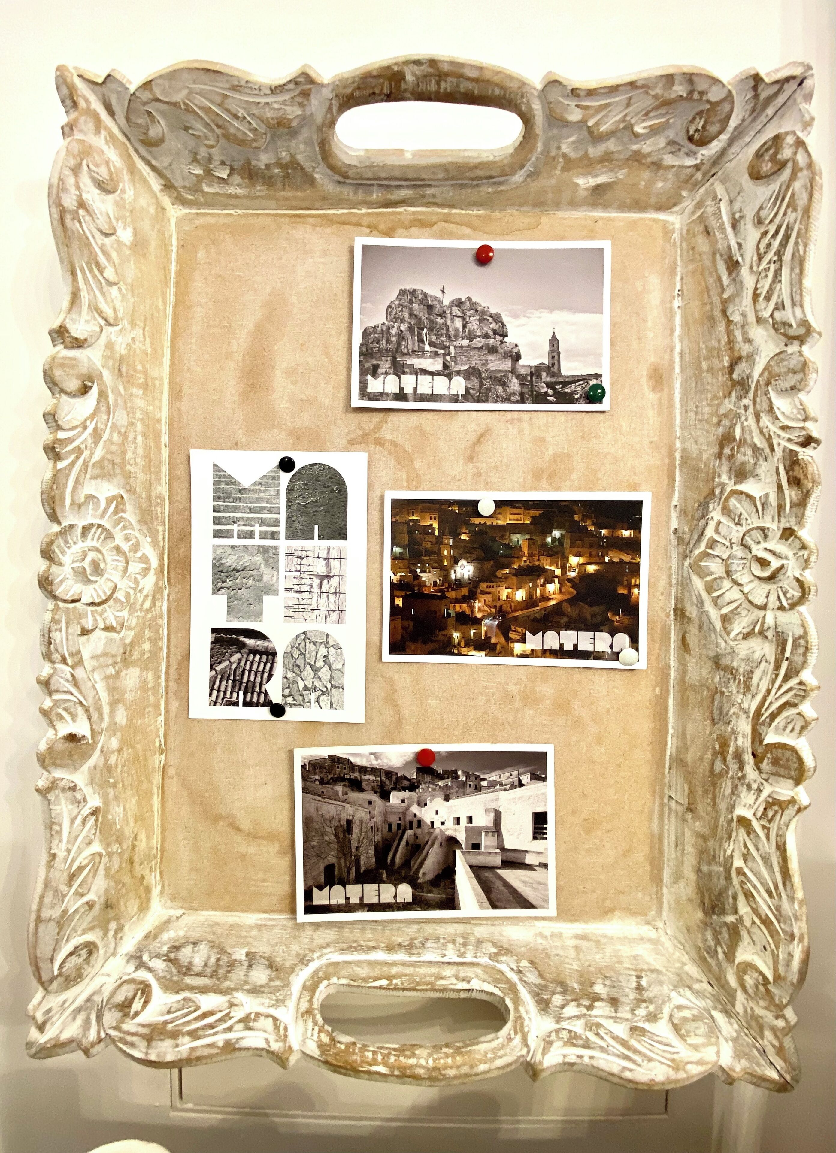 A corkboard with photos pinned to it, including images of a cityscape and architectural structures.