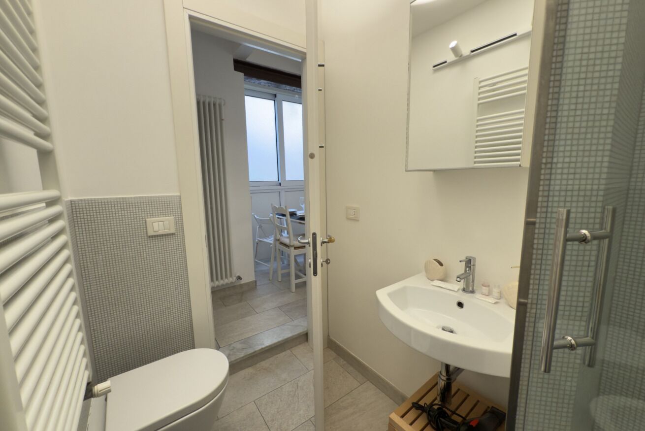 A bathroom with a toilet, sink, and shower area.