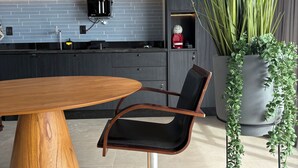 A modern kitchen with a dark backsplash, a coffee machine, and a potted plant. - ID URBAN LIFE LUXURY STUDIO FOREST (Setor Oeste Goiânia)