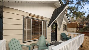 A porch with two Adirondack chairs, a small table, and a sign that reads "DON'T FEED THE BEARS". - Encino Pines (Big Bear Lake)