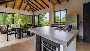 A modern kitchen with a large island, built-in appliances, and a view of the outdoors. - SANTA TERESA SURFING VILLA N°2 PRIVATE SWIMMING POOL OCEAN VIEW (Puntarenas Province)