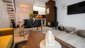A modern living room with a dining area, a staircase, and a kitchen in the background. - Comfortable Holiday Home, Sauna, Whirlpool (Mielno)