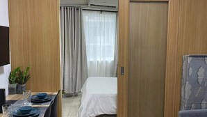 Een moderne kamer met een bed, een eethoek en een bank.