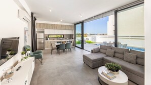A modern living room with a sofa, coffee table, and dining area.