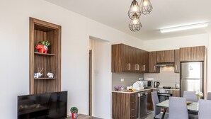 A modern kitchen with wooden cabinets, a built-in oven, and a stainless steel refrigerator. - 2 bedroom apartment in Kapparis AK14 (Kapparis)