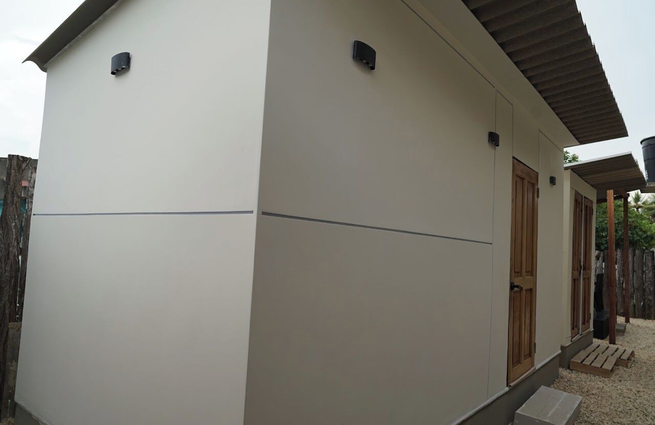 Un edificio moderno con techo plano, puerta de madera y un pequeño porche.