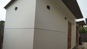 Ein modernes Gebäude mit Flachdach, Holztür und einer kleinen Veranda.
