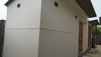 Un edificio moderno con techo plano, puerta de madera y un pequeño porche.