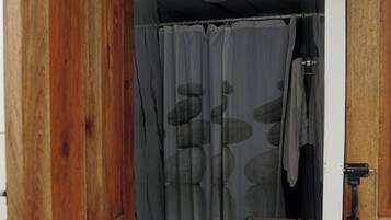 Puerta de madera que da a un baño con cortina de ducha estampada con un diseño de piedra.