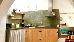 Une cuisine avec des meubles en bois, un évier et des lampes suspendues.