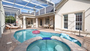 A swimming pool with a hot tub, sun loungers, and a covered patio area. - Luxe 3BR Villa w/ Heated Pool – Marco Island (Marco Island)