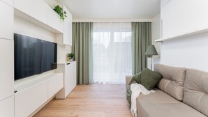 A modern living room with a flat-screen TV, a sofa, and a coffee table.