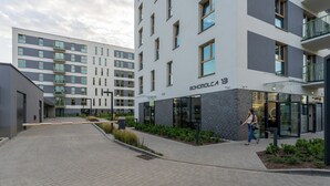 A modern building with a flat facade, multiple balconies, and a sign reading "BOHOMOLCA 13".
