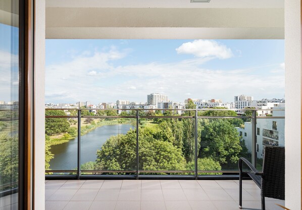 A balcony with a view of a river and cityscape.