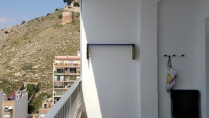 Un balcón con vista a una colina y edificios.