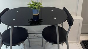 A round table with four chairs, a small plant in a blue vase, and a wall-mounted sign that reads "KEYS". - Charming 1-bedroom apartment with AC, WiFi in delightful Tampa (Tampa)