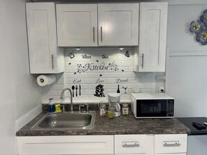 Fridge, microwave, coffee/tea maker, cookware/dishes/utensils