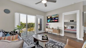 A modern living room with a sofa, coffee table, and a TV mounted on the wall. - Charming 1-bedroom apartment with AC, WiFi in delightful Cedar Park (Cedar Park)