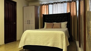 Ein Schlafzimmer mit Bett, Kleiderschrank und Tür.