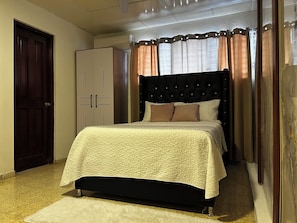 A bedroom with a bed, a wardrobe, and a door. - Dominico Colonial (Santo Domingo)