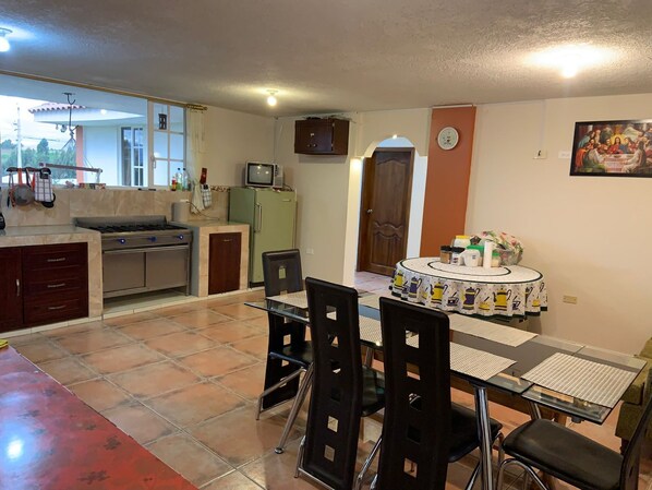 A compact kitchen with a dining area, including a table with chairs and a small refrigerator.