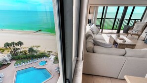 Un balcone con vista sull'oceano, una piscina e un'area salotto con divano e poltrona.