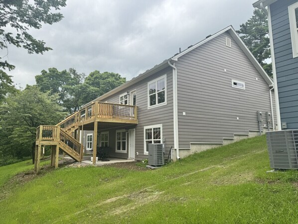 A two-story house with a wooden deck and a covered patio.