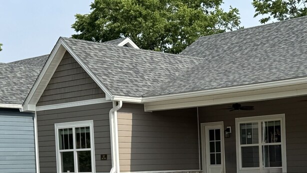 A two-story house with a grey roof, white trim, and a stone foundation. - American Pharoah Cottage | 3BR Downtown Versailles (Versailles)