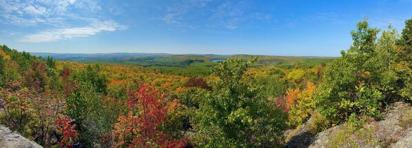 Un paysage montagneux aux couleurs automnales, sous un ciel dégagé.