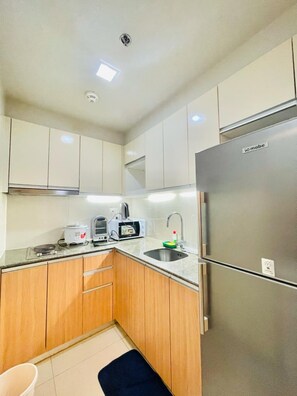 Full-size fridge, microwave, stovetop, cookware/dishes/utensils