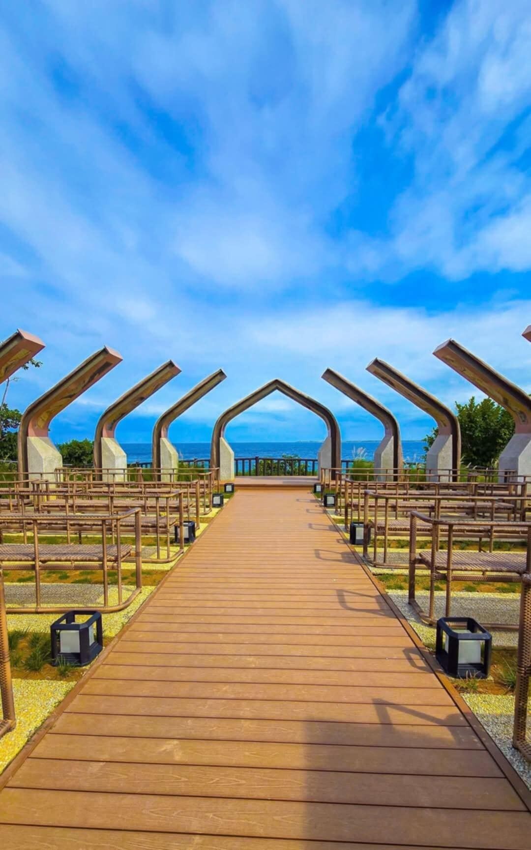 Un sendero de madera que lleva a una zona de estar con vista al océano.