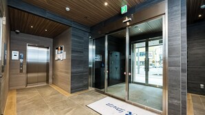 An elevator area with a digital display, a doormat, and a wooden ceiling. - Hotel Reference Ropponmatsu Condominium (Fukuoka)