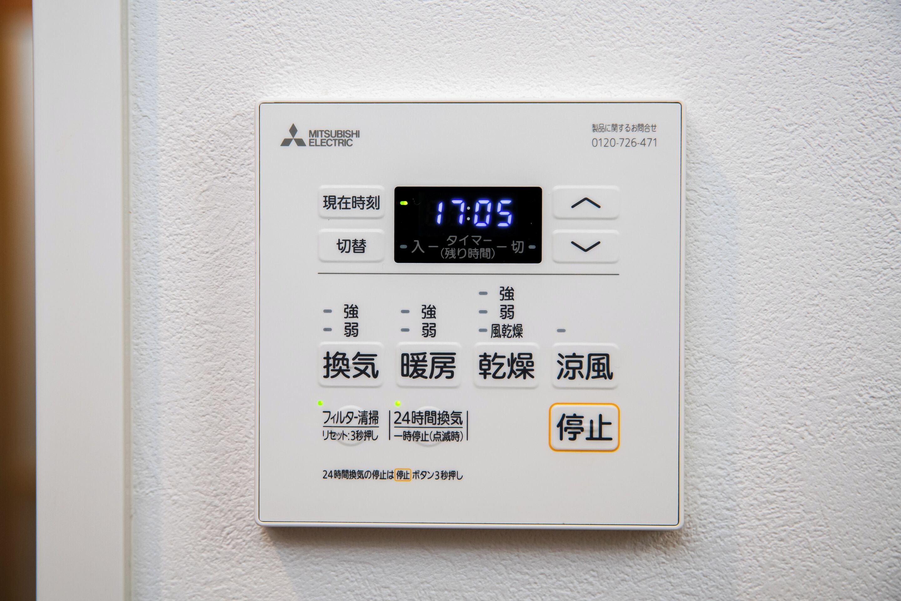 Een Mitsubishi Electric thermostaat aan een muur bevestigd.