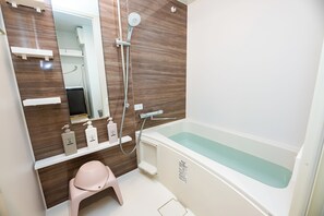 Un baño moderno con un espejo grande, ducha y bañera.
