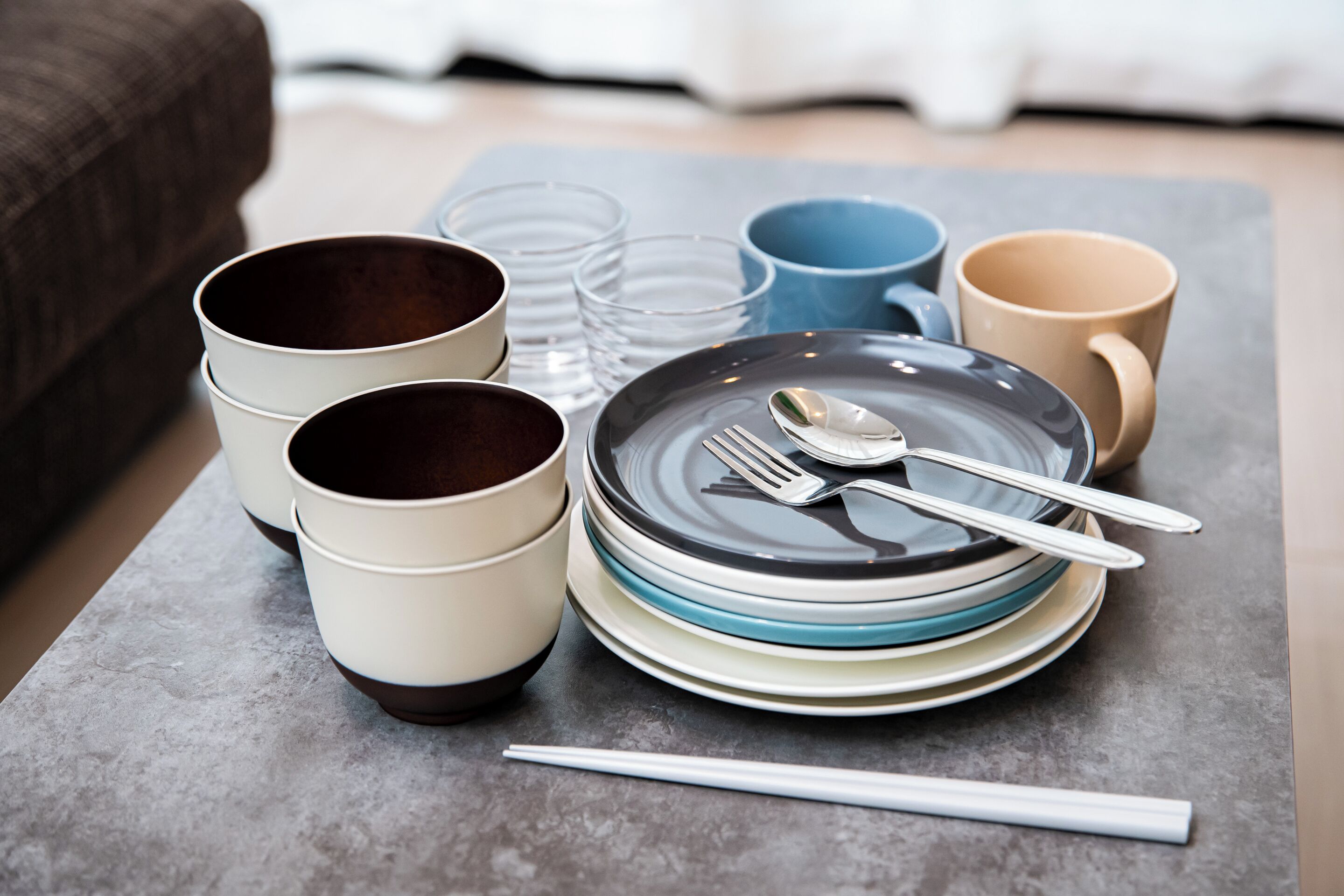 A dining setup with bowls, plates, and cutlery on a table.