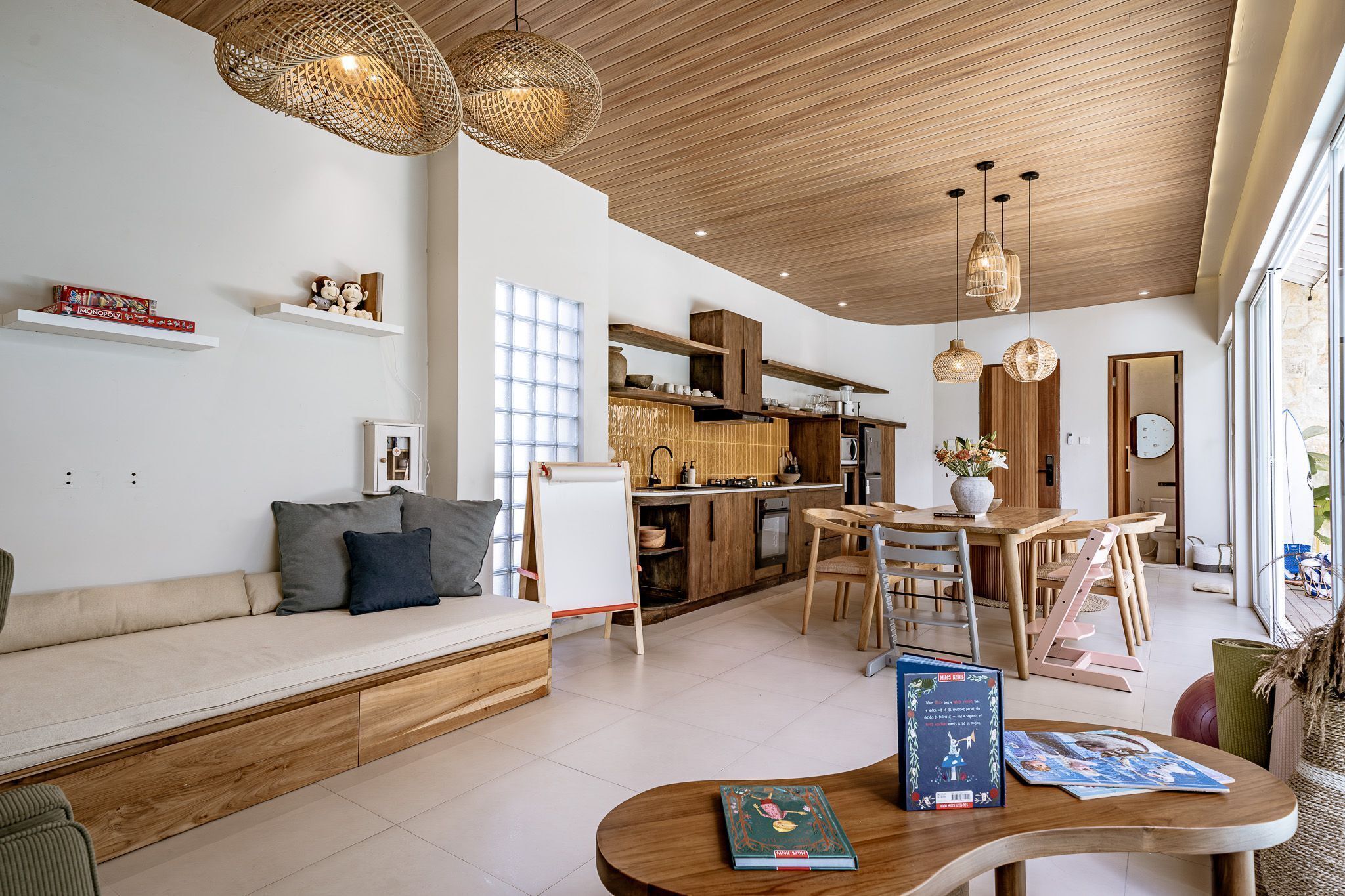 A modern living room with a wooden sofa, a dining area with a wooden table, and a kitchen with wooden cabinets.