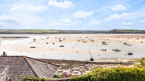 A coastal landscape with boats on a sandy beach and a view of the sea.