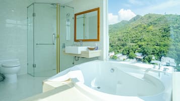 Suite estudio ejecutiva, 1 cama de matrimonio grande, vistas al mar | Baño | Ducha y bañera combinadas y cabezal de ducha tipo lluvia
