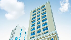 Un hotel alto con un letrero llamativo que dice "GLAMOUR HOTEL".