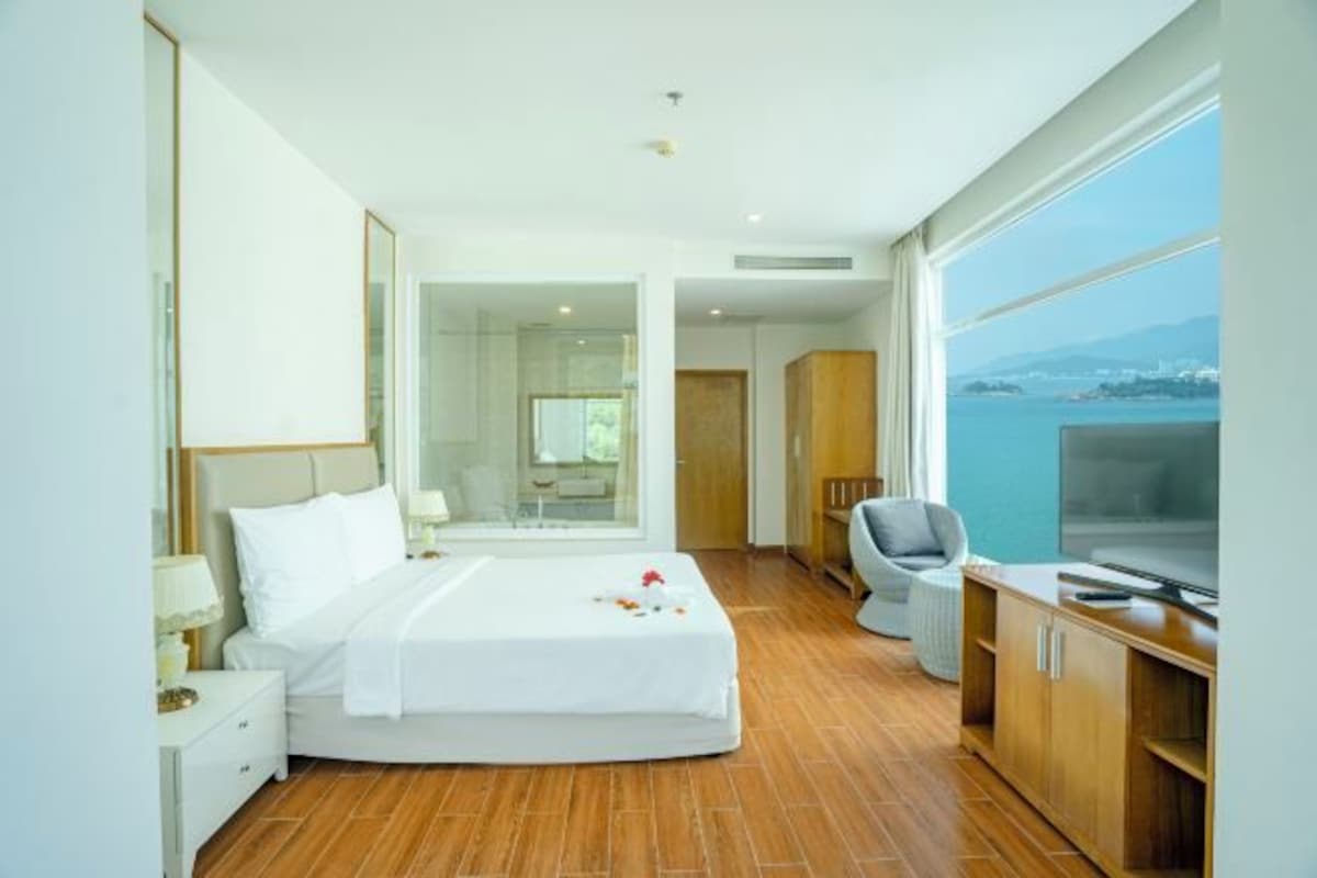 Une chambre d’hôtel moderne équipée d’un grand lit, d’un bureau, d’une chaise et d’un téléviseur.