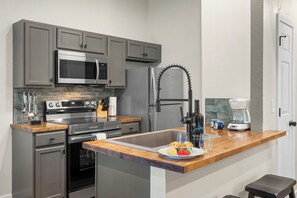 A modern kitchen with a built-in microwave, oven, and stainless steel appliances.
