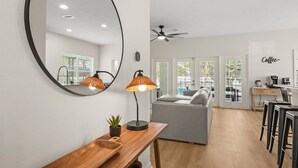A modern kitchen with a dining area, a large mirror, and a ceiling fan. - Modern Villa w/ Pool, Hot Tub & Theater Room! (Kissimmee)