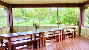 Un espace extérieur abrité, avec des bancs en bois et un tapis à motifs.