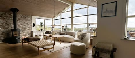 A spacious living room with a large window, a fireplace, and a cozy seating area.