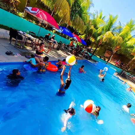 Una piscina al aire libre, sombrillas
