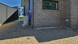 En moderne bygning med facade i mursten, et vindue og en garageport.